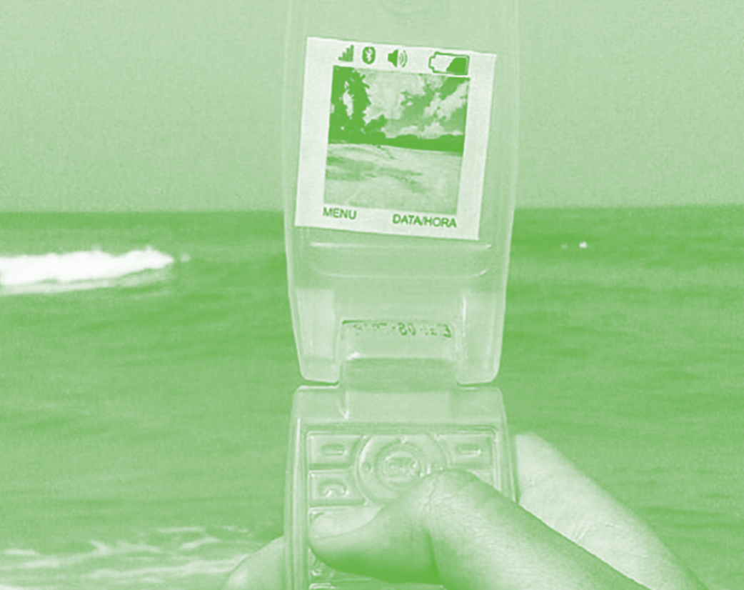 TQRMag.png Photo in green scale of a hand holding a retro cell phone