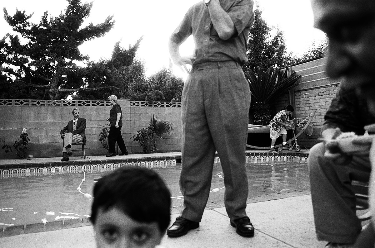 TracesOfIdentity-AraOshagan.jpg black & white photo of people standing around a pool, foreground & background