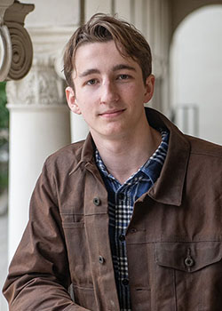 Will McMillan headshot with light brown coat
