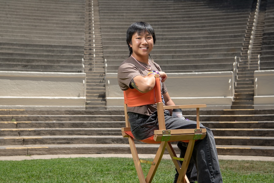 an occidental student sits a directors chair in the Remsen Bird Amphitheater