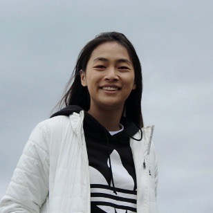 An Occidental College student in a white coat with dark hair