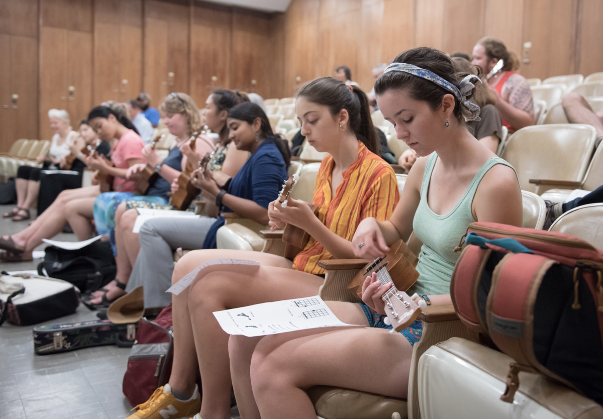 Students playing ukulele from a chord chart