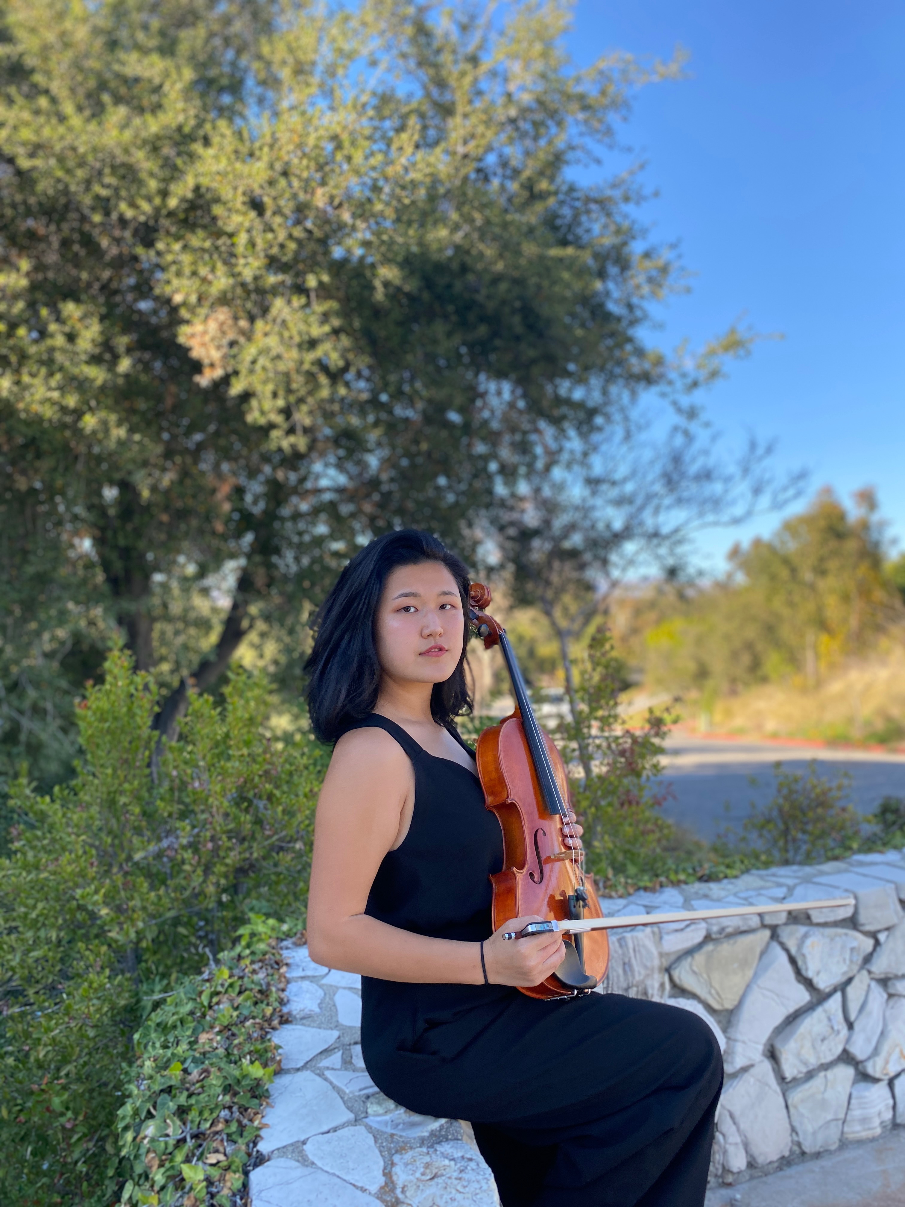 Hyun Gill '22 posing with her viola near the E. Norris Dormi