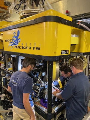 Three male pilots repair ROV Doc Ricketts