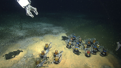 A robot collects experiments from the seafloor