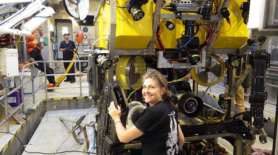 Occidental College professor Shana Goffredi smiling in front of a deep sea ocean research vessel Occidental College professor Shana Goffredi smiling in front of a deep sea ocean research vessel