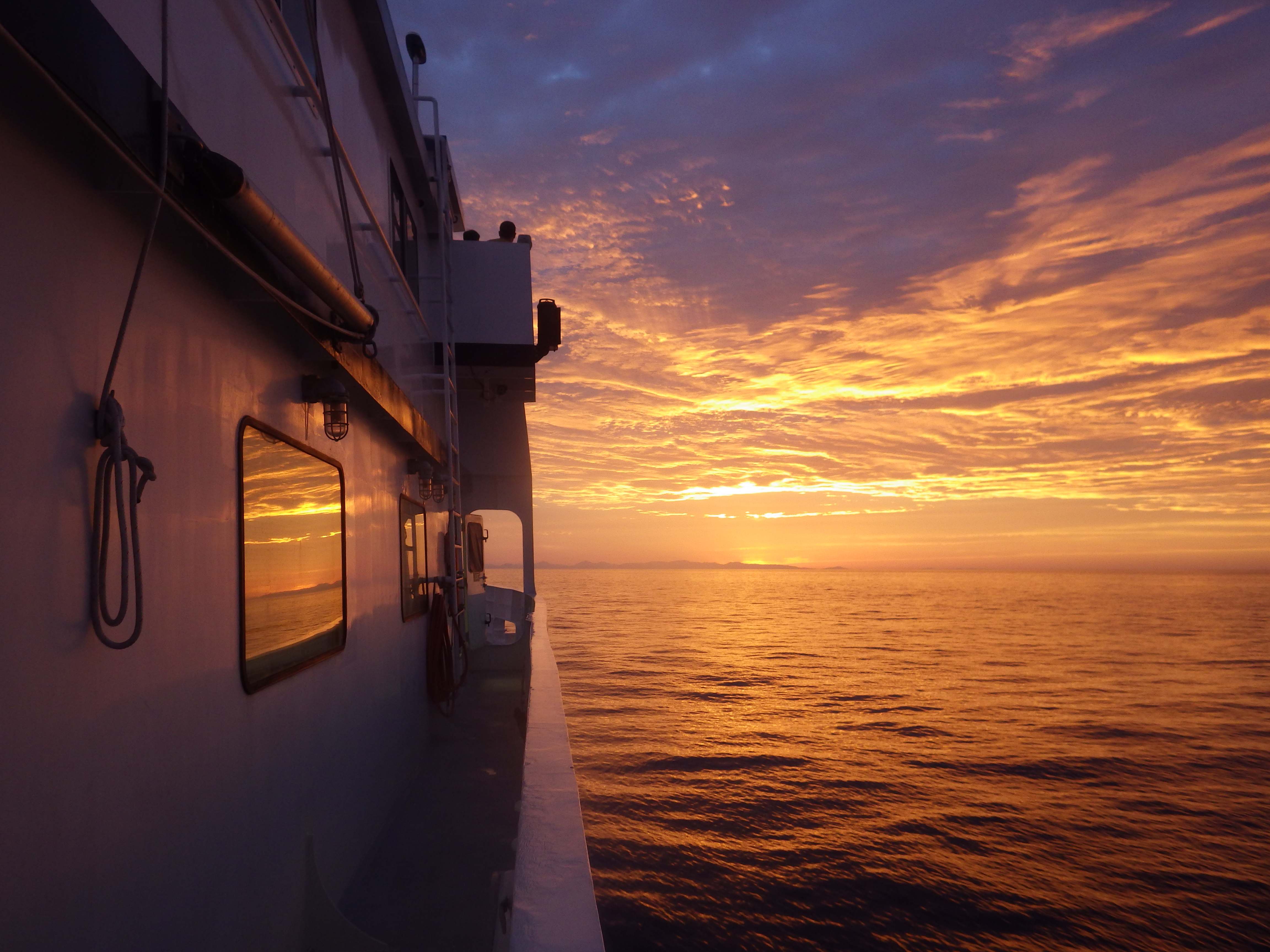 A view of a colorful sky at sunset from a boat on the sea