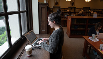A student studies by herself in the Oxy library
