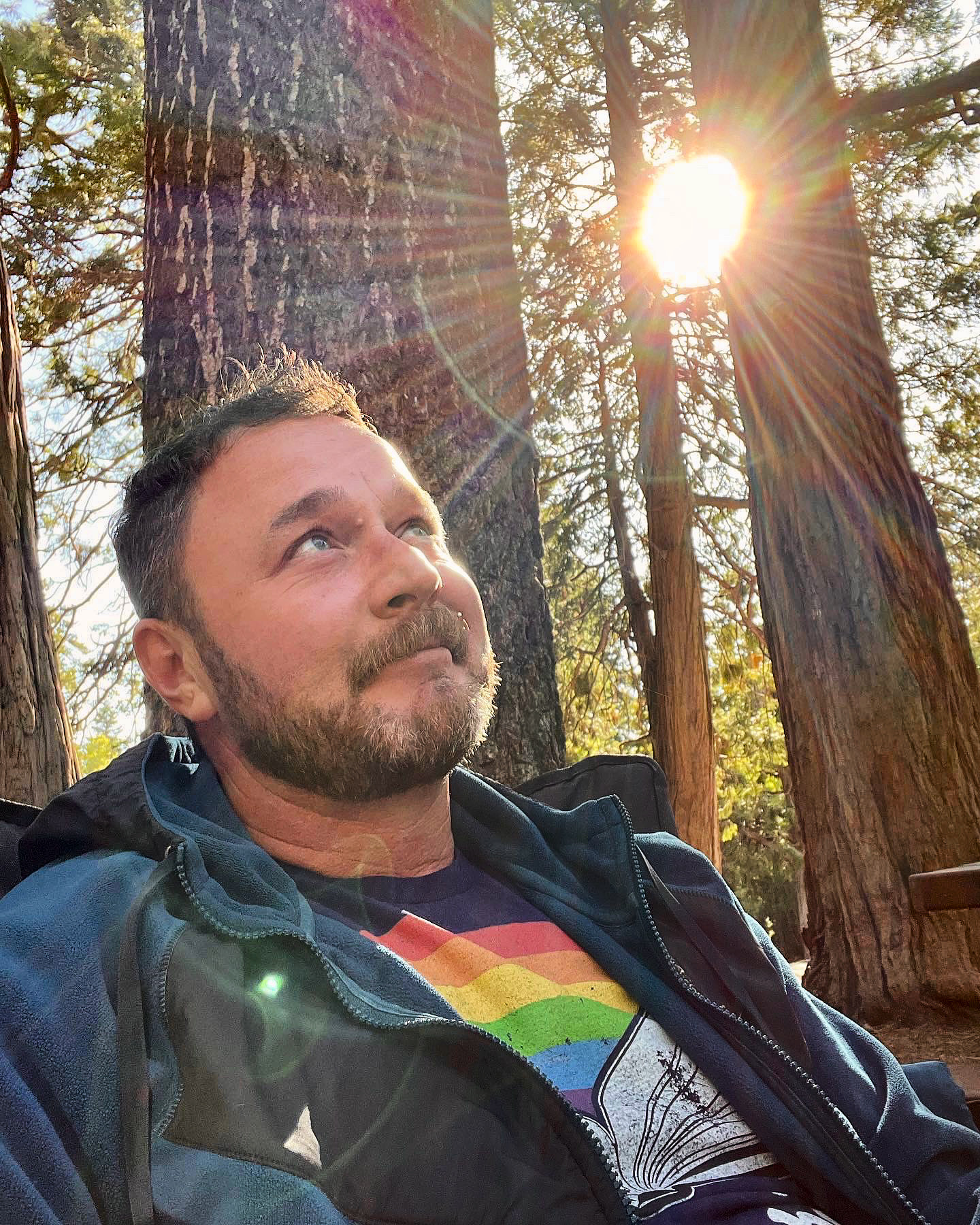 a photo of jason wise wearing a shirt with a rainbow on it