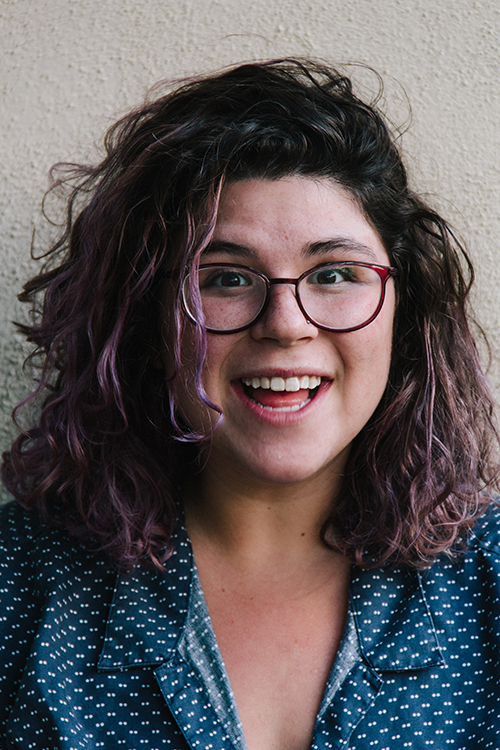 Molly has curly dark hair with purple streaks
