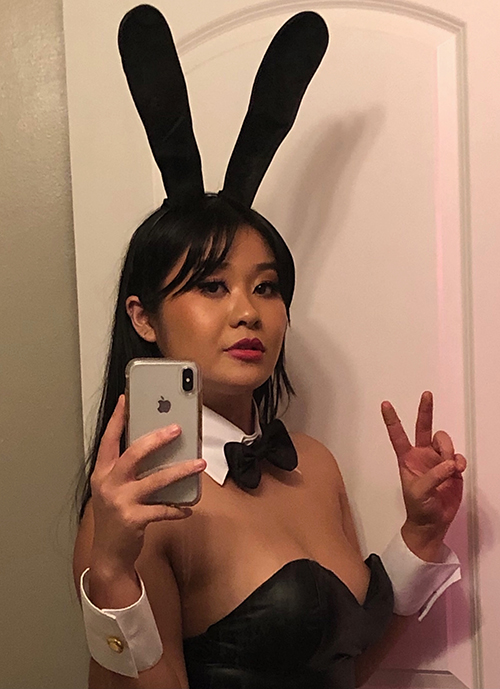 Sandy is wearing black bunny ears and a strapless tuxedo style top