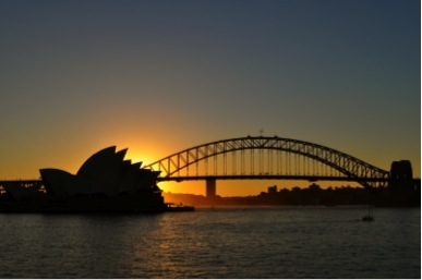 A view of the Sydney opera house and a bridge at sunset