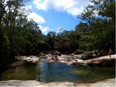 a swimming hole amid a rocky area ringed by trees