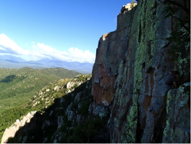 A view of a steep cliff, partly in shadows
