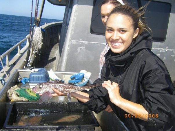 An Occidental College student holds a Trawling Chimaera in her hand on a boat.