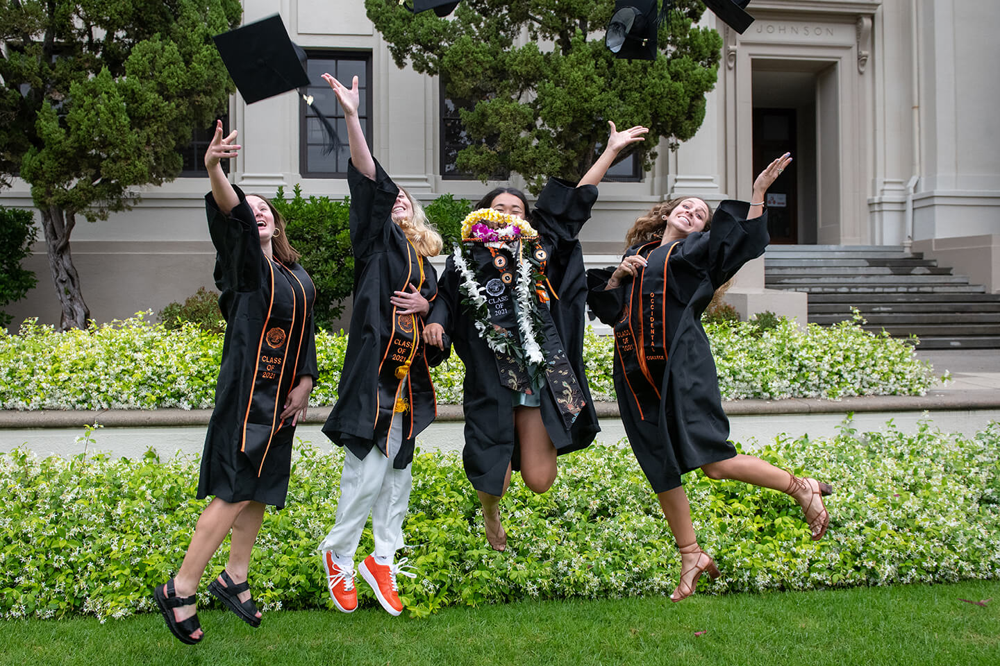 Graduates jumping in front of a building