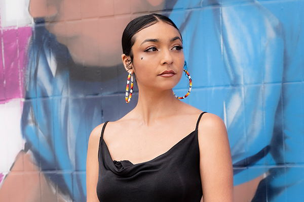 Fox Maxy standing in front of a painted wall