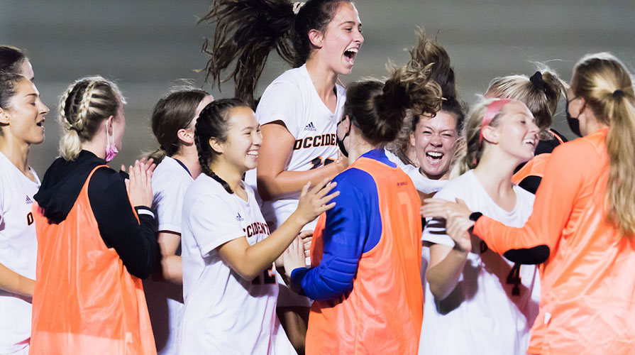 women's soccer players celebrate a win on the field