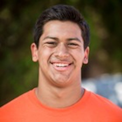 Dominic Rios, a young man, smiles at the camera.