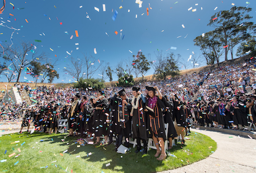 Occidental graduates celebrating with confetti in the air