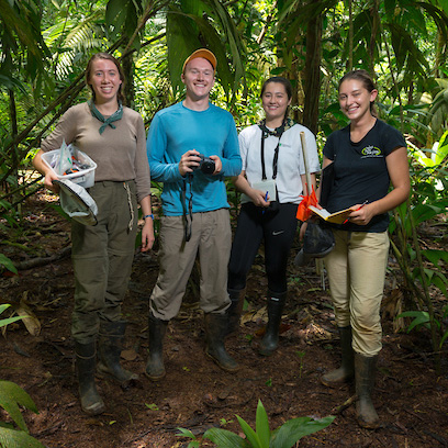 Students in Costa Rica pose in jungle with cameras and data collection materials
