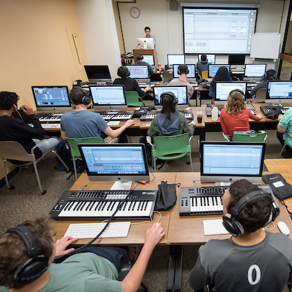 Music production students use electronic keyboards and computers in classroom