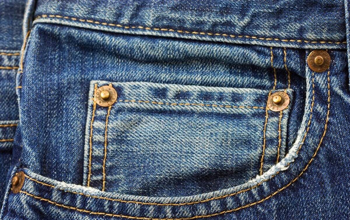 Blue denim pocket with yellow stitching.