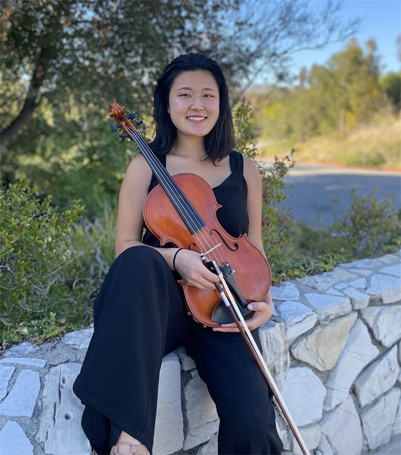 Hyun Gill sitting with her viola