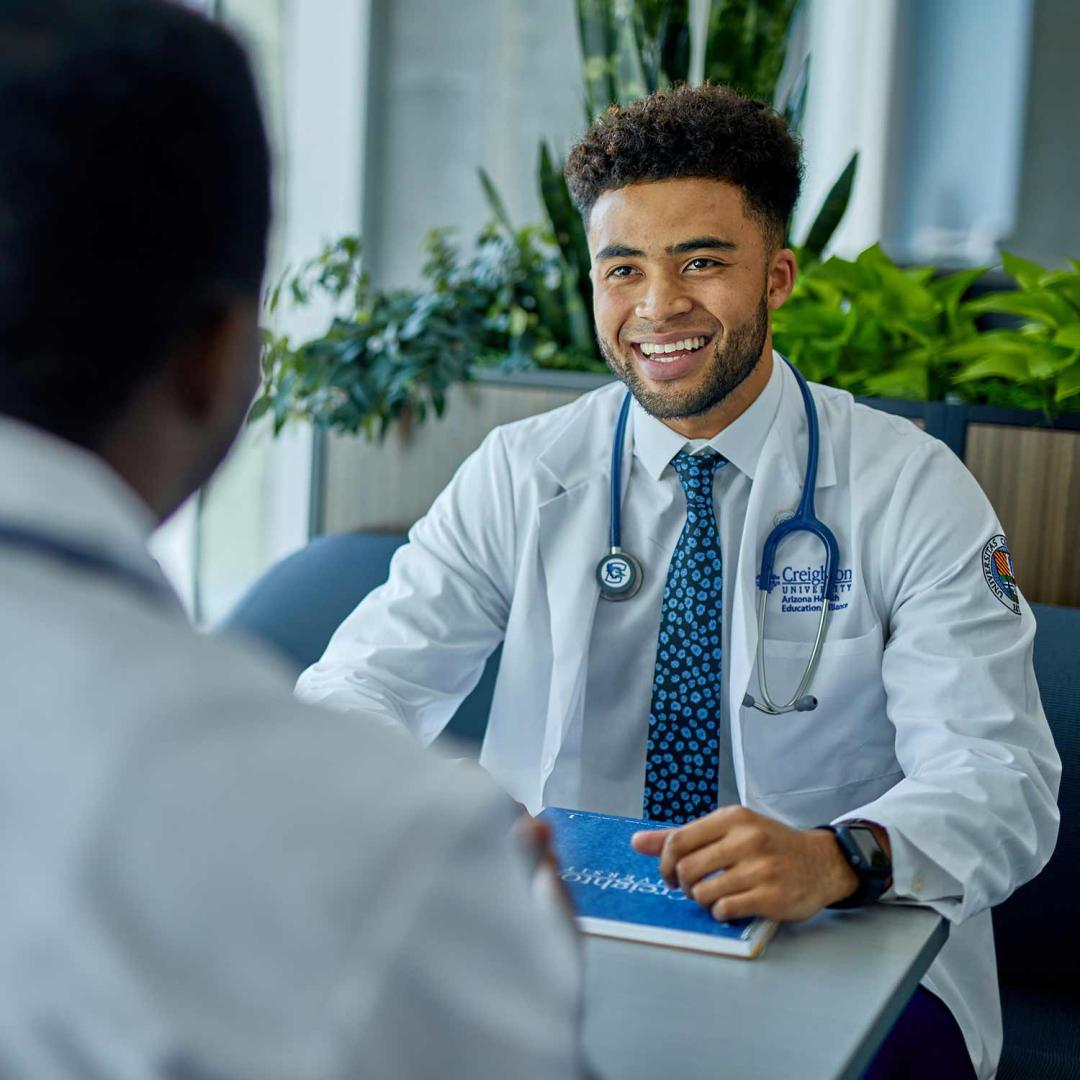 a young physician's assistant in a white coat