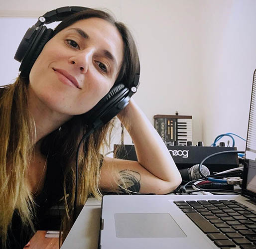 Professor Ramona Gonzalez ssitting at her desk making music