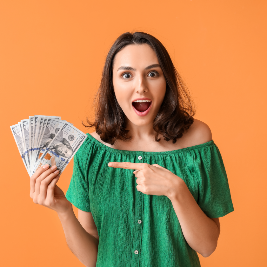 Surprised young woman holding money on colored background