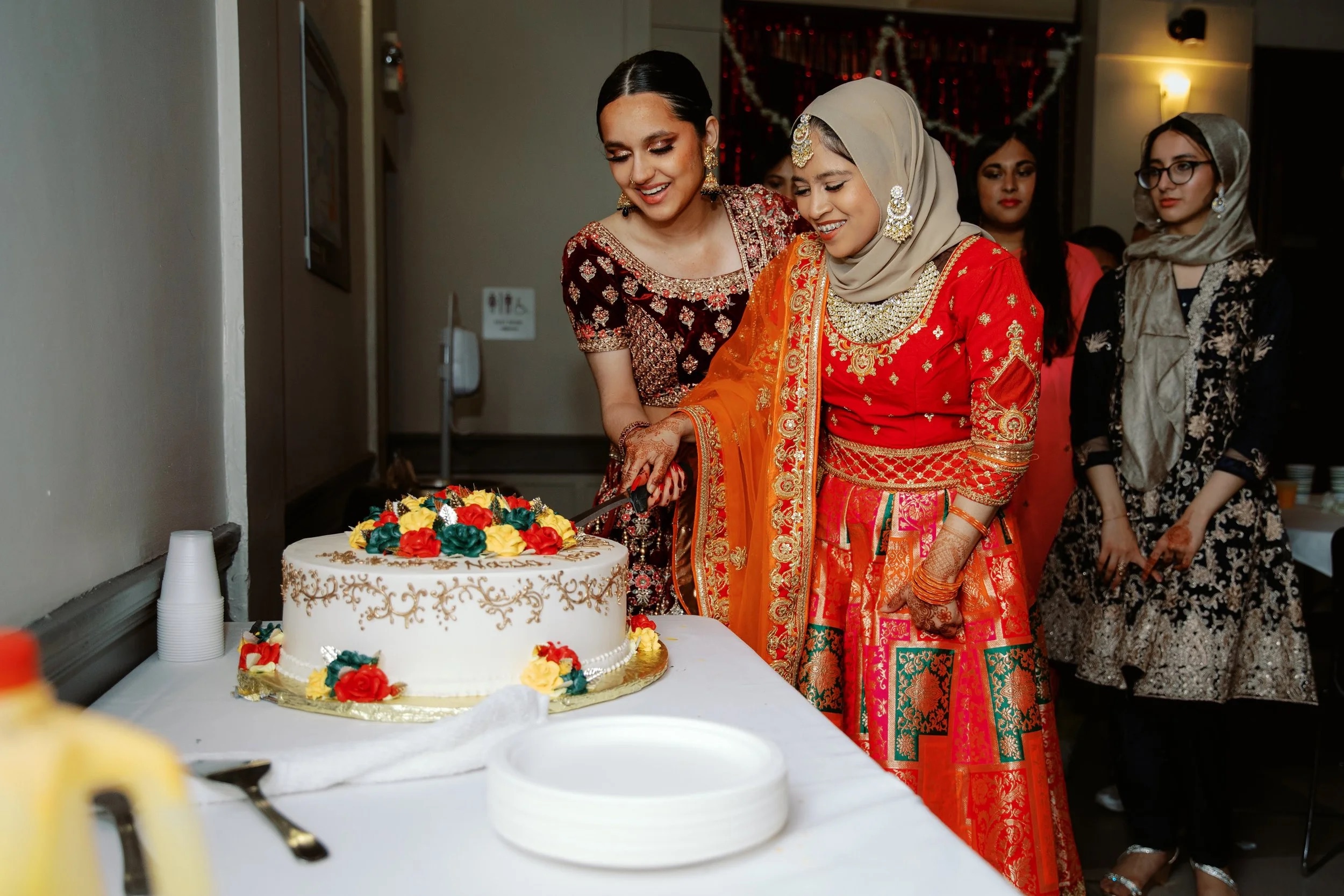 Image of two people cutting cake at a Mock Shaadi (Wedding)