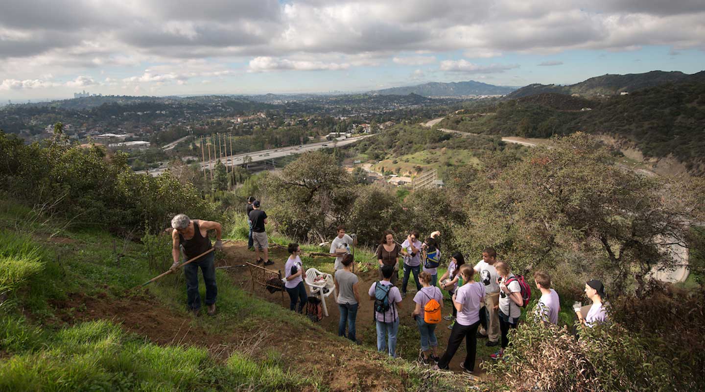 Oxy student volunteers work in a garden overlooking East LA
