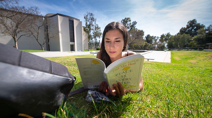 student reading on campus