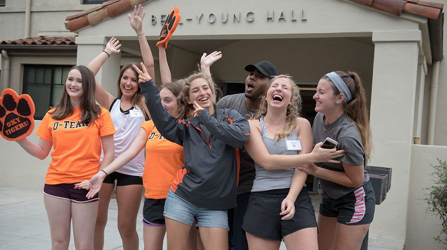 students standing to greet new students during move in day