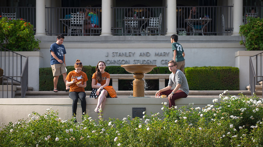 Students sit in front of Johnson Student Center