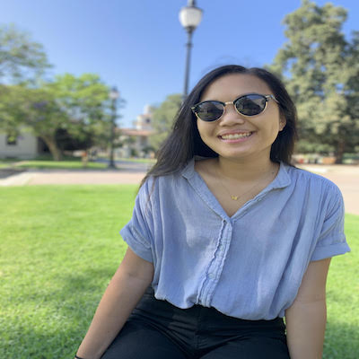 photo of Charlene Chen sitting outside on the grass with sunglasses on