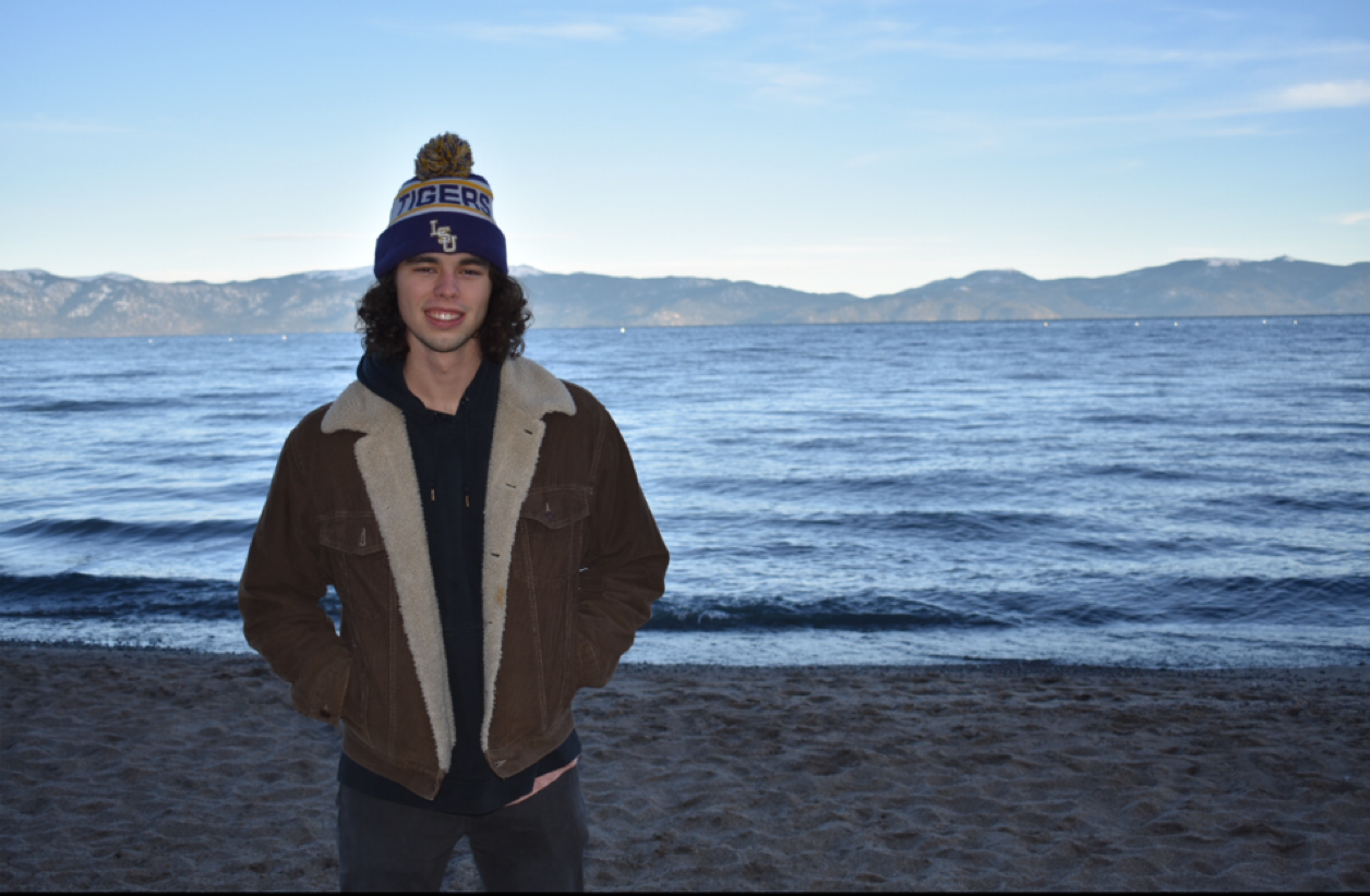 River Flot standing next to a lake with mountains in the background