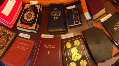 Sacred texts from around the world arranged on a wooden table