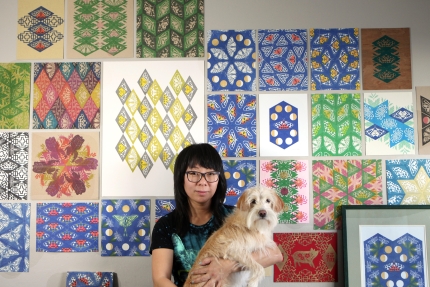 Jennifer Zee holding dog in front of art