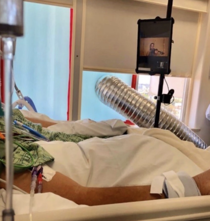 A COVID-19 patient at Scripps Mercy Hospital San Diego watches a private concert by a professional violinist on an iPad in his room on July 17. (Courtesy of Scripps Mercy Hospital San Diego)