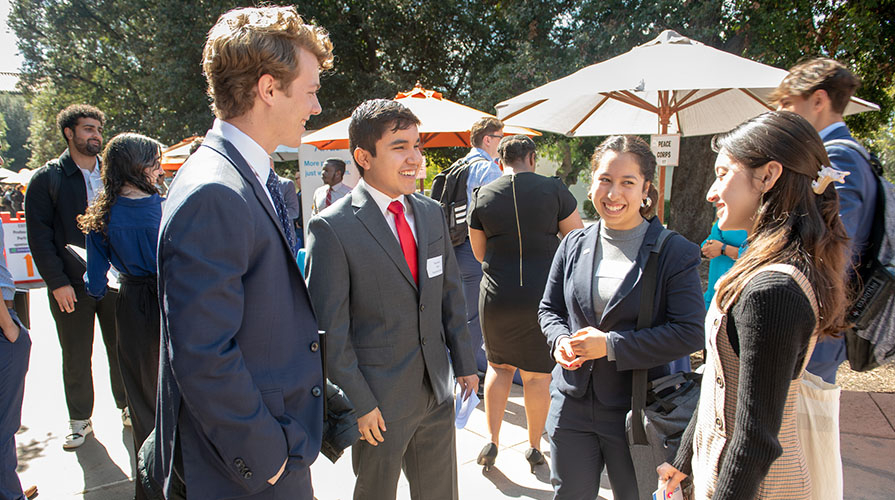 Four Occidental students in business attire at the Oxy Career Fair