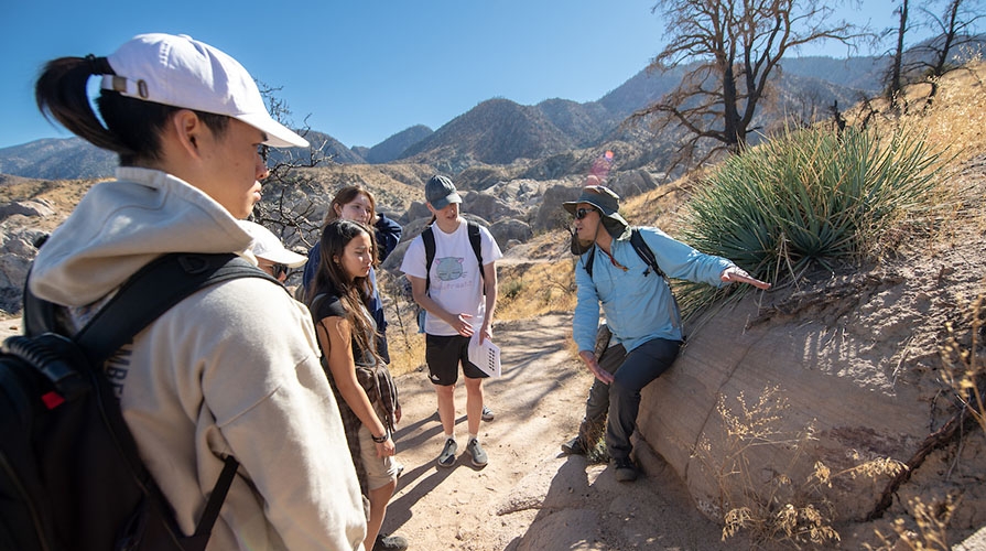 An Occidental College geology professor talks to his students about rock formations in the field