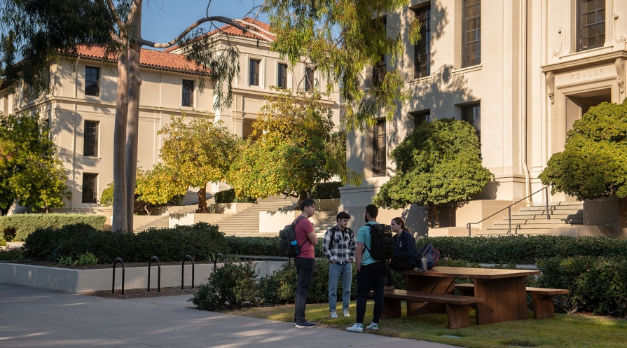 students standing in front of Fowler Hall, talking