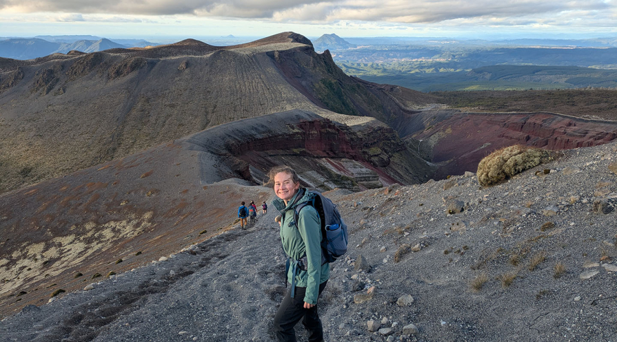 An Occidental College student in the mountains, facing the camera and smiling