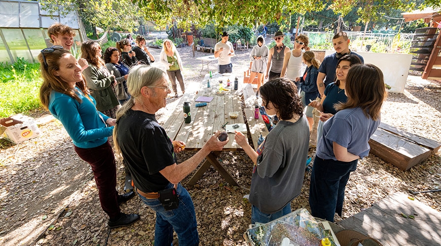Bruce Steele and a group of Occidental College students and staff hanging out in the FEAST garden on campus