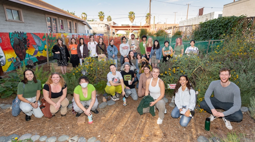 A large group of Occidental College sustainability students in an urban garden as part of a field trip