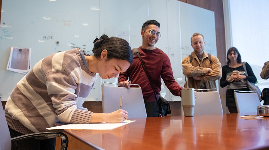 Occidental transfer students at the president's office, around a table.