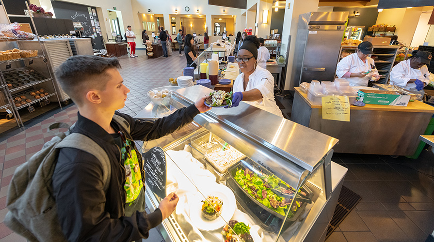 A student gets a salad at the Marketplace at Occidental College in Los Angeles
