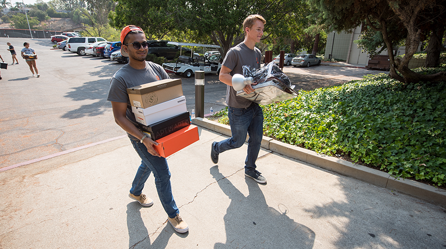 Occidental students bring boxes into the residence hall on move in day